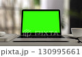 Greenscreen display on laptop set on white table. Blurred Home office workspace. Chroma key on screen for Video Call, Website Template Presentation Game Applications. Freelance Business. Zoom in 130995661