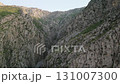 Aerial view into a dramatic cliff canyon in Uzbekistan during golden hour 131007300
