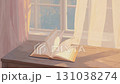An open book on a windowsill and fluttering curtains 131038274