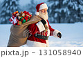 Santa walking through snow, carrying a bag full of presents, christmas spirit concept footage 131058940
