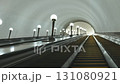 Long escalator going up in metro station with many lights illuminating the path 131080921