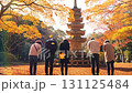 A family of five stands before a traditional stone pagoda, surrounded by vibrant autumn foliage. They bow their heads in a moment of prayer or respect. A family of five stands before a traditional stone pagoda, surrounded by vibrant autumn foliage. They bow their heads in a moment of prayer or respect. 131125484