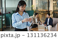 Young 25s Asian woman using smartphone in coworking office 131136234