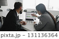 Two professionals discussing data displayed on laptop screen 131136364