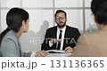Hispanic businessman in black suit hold meeting with women colleagues 131136365