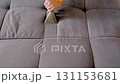 Professional cleaner hands using vacuum cleaner to remove dust stains from sofa. 131153681