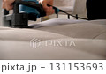 Cleaning service worker removing stains from sofa using electric brush machine. 131153693