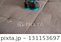 Cleaning service removing stain from sofa using electric brushing machine. 131153697
