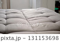 Cleaning service worker spraying foamy detergent on sofa in client's home. 131153698
