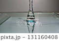 Close up of water droplet splashing reflective surface, creating ripples and serene, 4k video 131160408