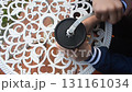 Hands Grinding Coffee Beans with Manual Grinder on Decorative White Table for Coffee Brewing 131161034