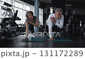 Mature man and woman are doing exercises on yoga mats in a gym 131172289