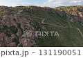 Black car driving on mountain ridge road near canyon 131190051