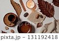 Cozy Autumn Still Life with Candle and Earth Tone Ceramics 131192418