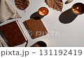 Autumnal Ambiance with Candles and Journals on White Surface 131192419