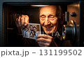 An elderly man opens a safe and finds a treasured family photo. His warm smile reveals the joy of reminiscing about his loved ones and their shared moments together. 131199502