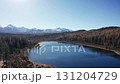 Autumn view of blue mountain lake with sunlight reflecting on surface of lake, snow-capped mountain peaks on background. Forward Flight approach drone shot of Lake Kidelyu, Ulagansky Track, Altai 131204729