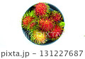 Top view rotation of ripe sweet rabutan fruits in black ceramic dish. 131227687