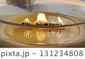 Large scented candle in glass jar burning in cozy autumn home interior, warm hygge atmosphere, aromatherapy 131234808