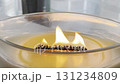 Large scented candle in glass jar burning in cozy autumn home interior, warm hygge atmosphere, aromatherapy 131234809