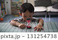A child watches as time slips away with an hourglass 131254738