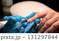 A skilled technician meticulously works on a clients nails using specialized tools for a flawless manicure experience in a serene salon. 131297844
