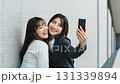 Two girls taking selfies in different poses 131339894