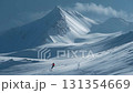 Backcountry skier enjoying the descent on fresh snow with majestic mountain peak in the background 131354669