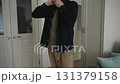 Man putting on shirt as part of minimal lifestyle 131379158