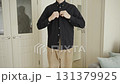 Man buttoning shirt in minimal home interior 131379925