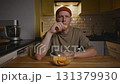 Man enjoying quiet snack with chips in evening kitchen atmosphere 131379930