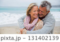 Romantic middle-aged couple enjoying a peaceful evening together on the beach. Love, connection, and togetherness concept for mature relationships and slow living lifestyle 131402139