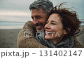 Romantic middle-aged couple enjoying a peaceful evening together on the beach. Love, connection, and togetherness concept for mature relationships and slow living lifestyle 131402147
