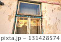View of the worn facade of an old house. View of the old facade of the house, its windows and gates. Concept of property agencies, reconstruction in the construction business. Slow motion. 131428574