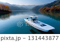 一艘現代化的電動船靜靜地停泊在湖水的絢麗色彩之中。 131443877