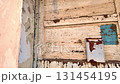 View of the worn facade of an old house. View of the old facade of the house, its windows and gates. Concept of property agencies, reconstruction in the construction business. Slow motion. 131454195