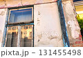 View of the weathered facade of an old house. View of the old facade of the house, its windows and gates. Concept of real estate agencies, reconstruction in the construction industry. Slow motion. 131455498
