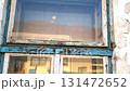 View of the worn facade of an old house. View of the old facade of the house, its windows and gates. Concept of property agencies, reconstruction in the construction business. 131472652