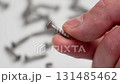 Metal screw in the hand of a mechanic in a workshop close up. 131485462