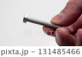 Metallic threaded bolt in the hand of a mechanic on a white background. Industry tool concept 131485466