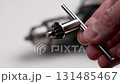 Drill chuck key in a repairman hand in a workshop close up 131485467