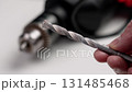 Used concrete drill bit in a repairman hand in a workshop close up 131485468