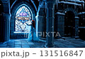 Medieval Christmas scene with woman in blue dress standing by gothic cathedral stained glass window in snowy winter night 131516847