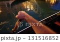 Gondola ride passing under illuminated Rialto Bridge at night in Venice Italy with golden reflections on Grand Canal water 131516852