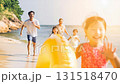 A family running happily along the beach 131518470