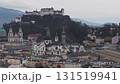Slow sweeping aerial view of Salzburg, Austria, featuring the Salzach River, Salzburg Cathedral, Hohensalzburg Fortress, and surrounding mountains. 131519941