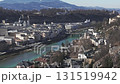 Aerial pan of Salzburg, Austria, featuring the Salzach River, Hohensalzburg Fortress, Salzburg Cathedral, historic buildings, and surrounding hills. 131519942
