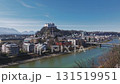 Aerial view of Salzburg, Austria, showing the Salzach River, Hohensalzburg Fortress, Salzburg Cathedral, bridges, and tree lined pathways. 131519951