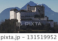 Aerial view of Salzburg, Austria, featuring a red domed clock tower, traditional buildings, a forested hillside, and an inclined pathway or track. 131519952