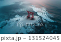 A winter scene of a red torii gate standing on a rocky outcrop on a snow-covered coast and rough waves 131524045